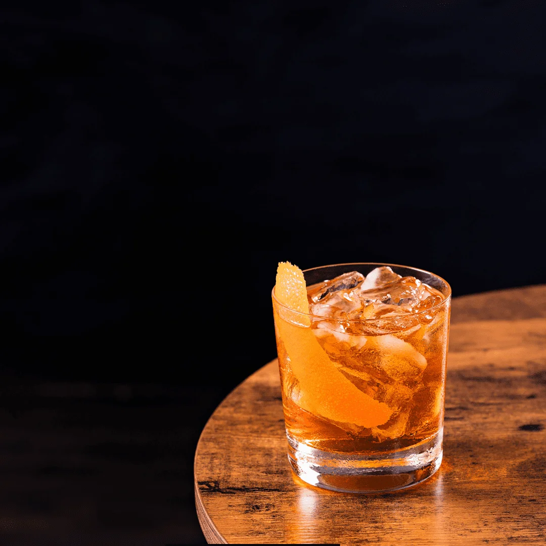 Old Fashioned cocktail over ice with an orange peel garnish