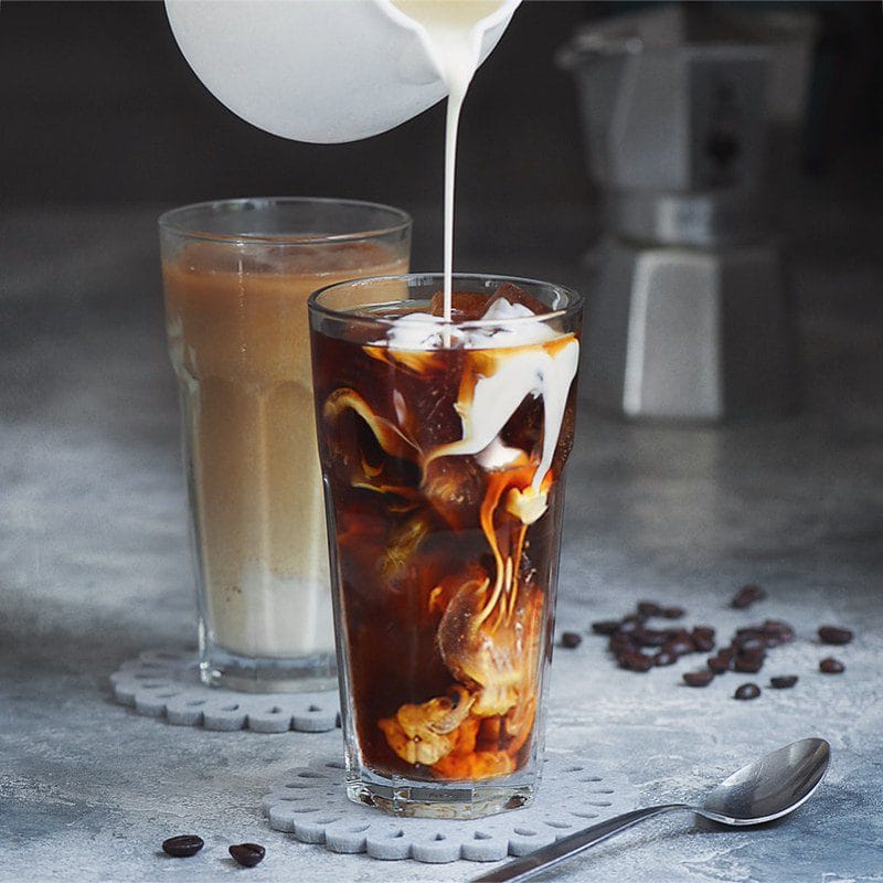 Campout Cold Brew (Dutch Bros-Inspired) in a glass with pouring milk swirling in