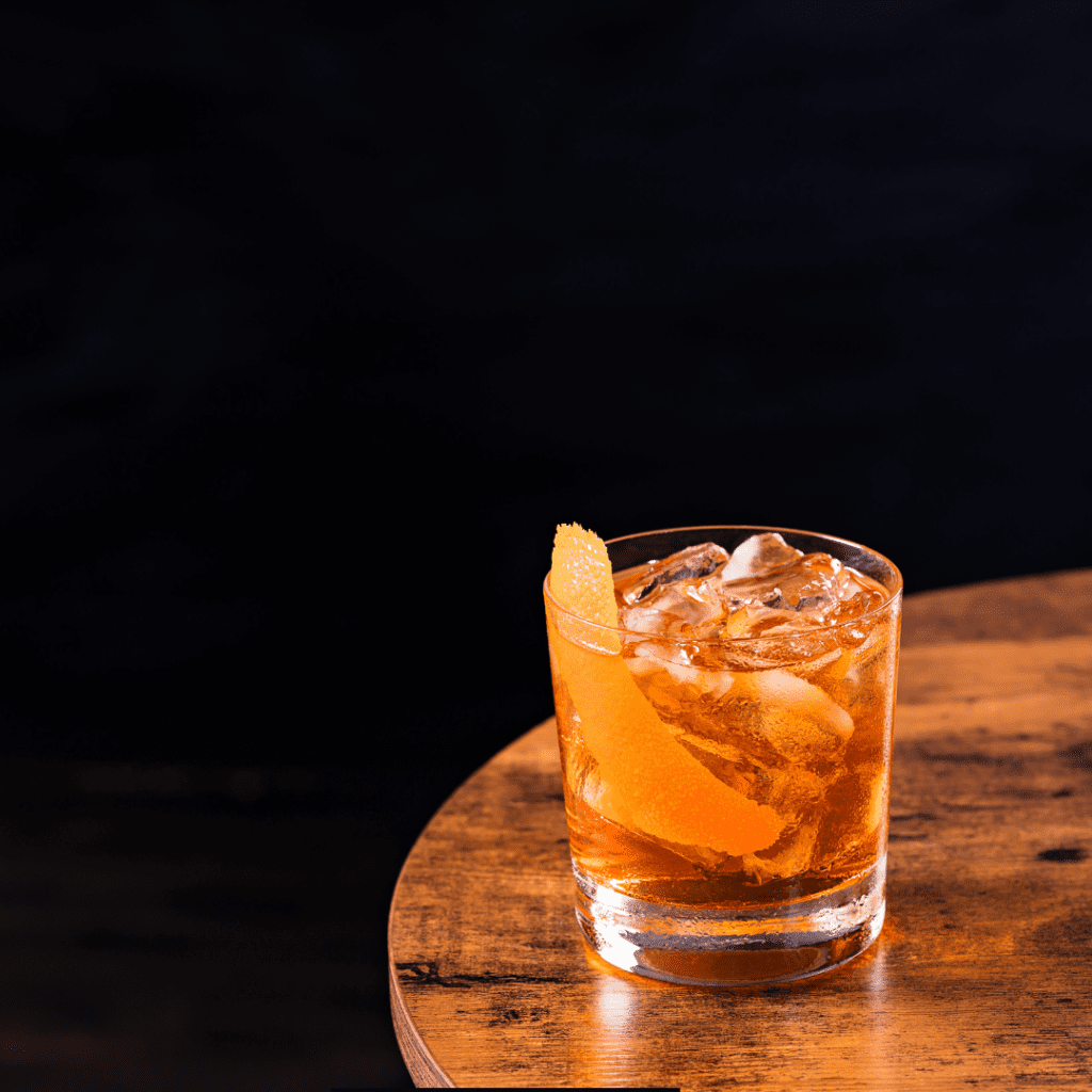 Old Fashioned cocktail over ice with an orange peel garnish