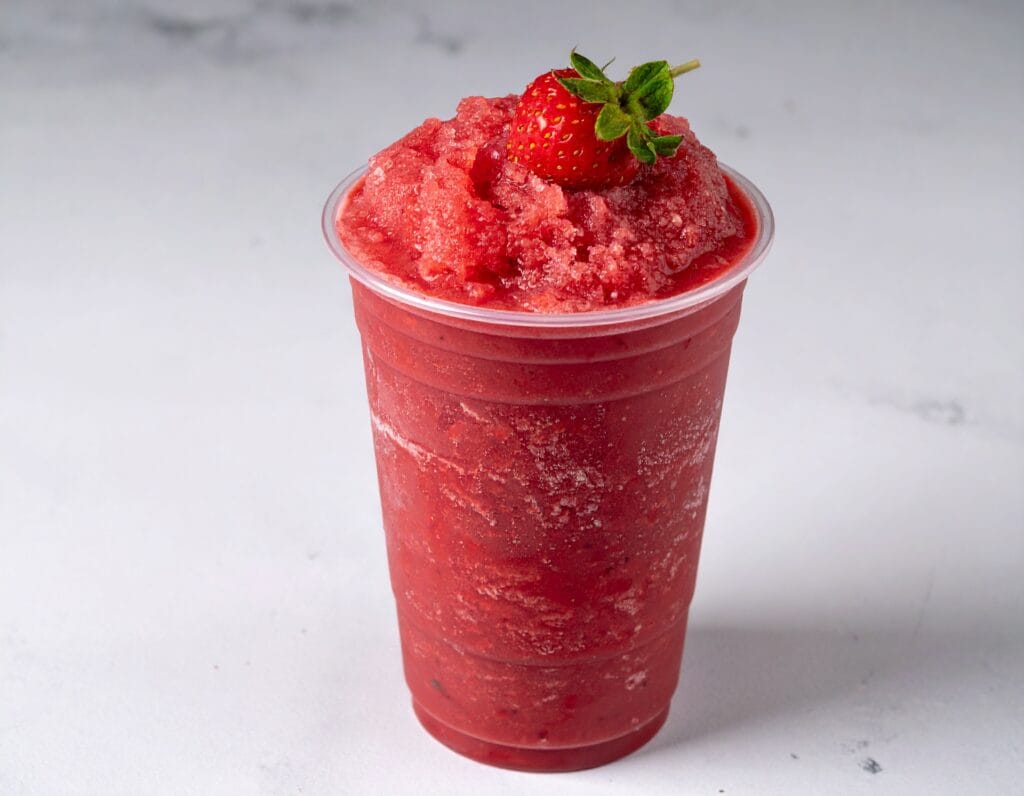 Frozen Strawberry Acai lemonade with a strawberry on top.